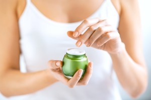 Close up of woman holding jar of cream