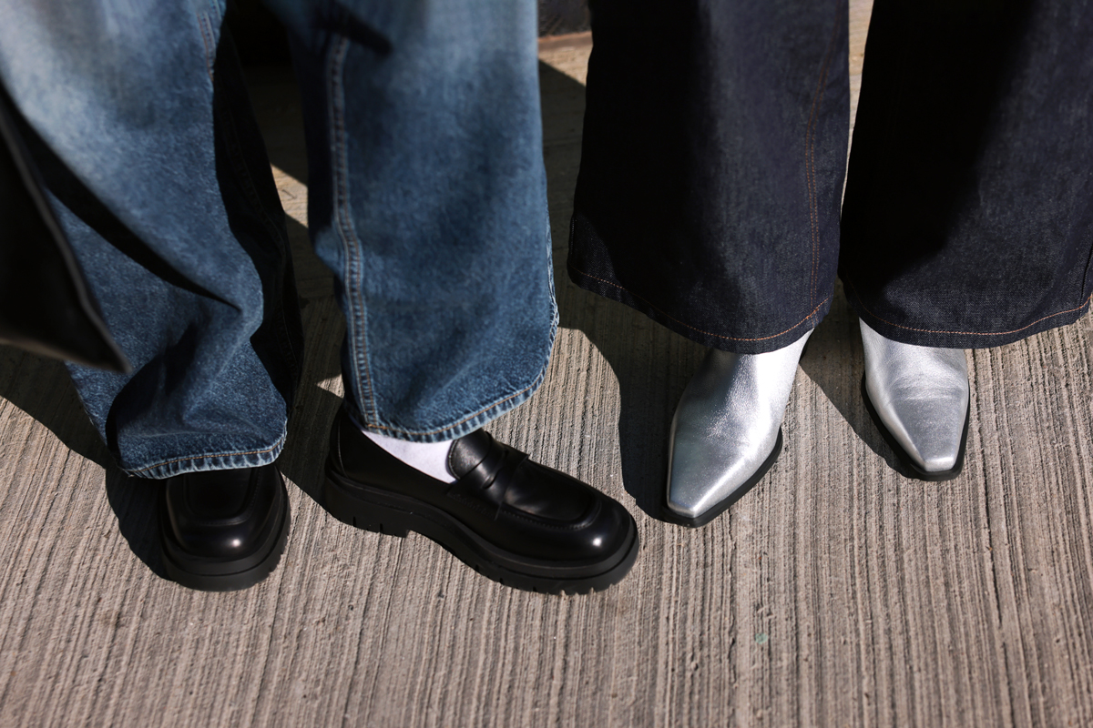 Cropped image of two people wearing stylish shoes with wide-leg pants