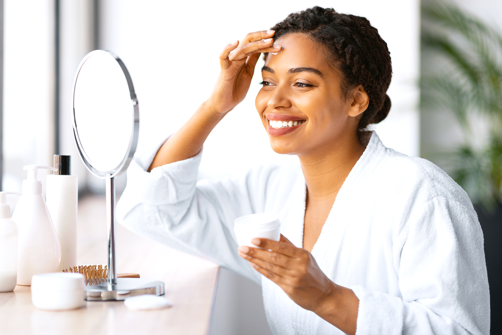 Woman putting lotion on her face