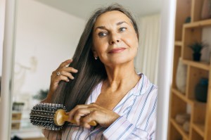 Woman combing grey hair