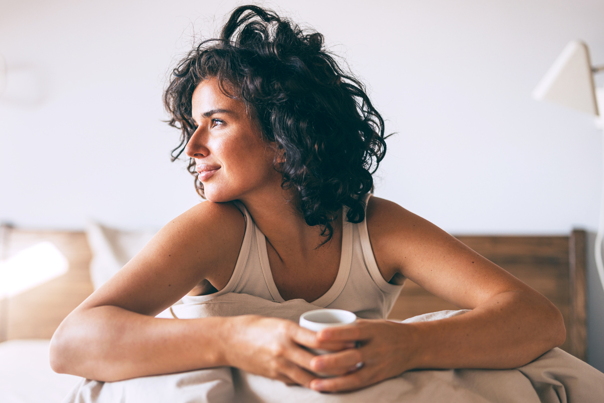 Woman in bed with coffee mug