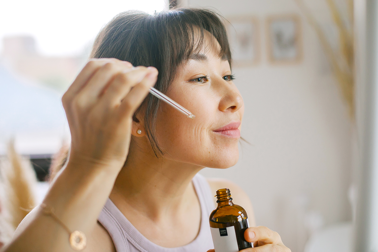 Woman applying serum to her face