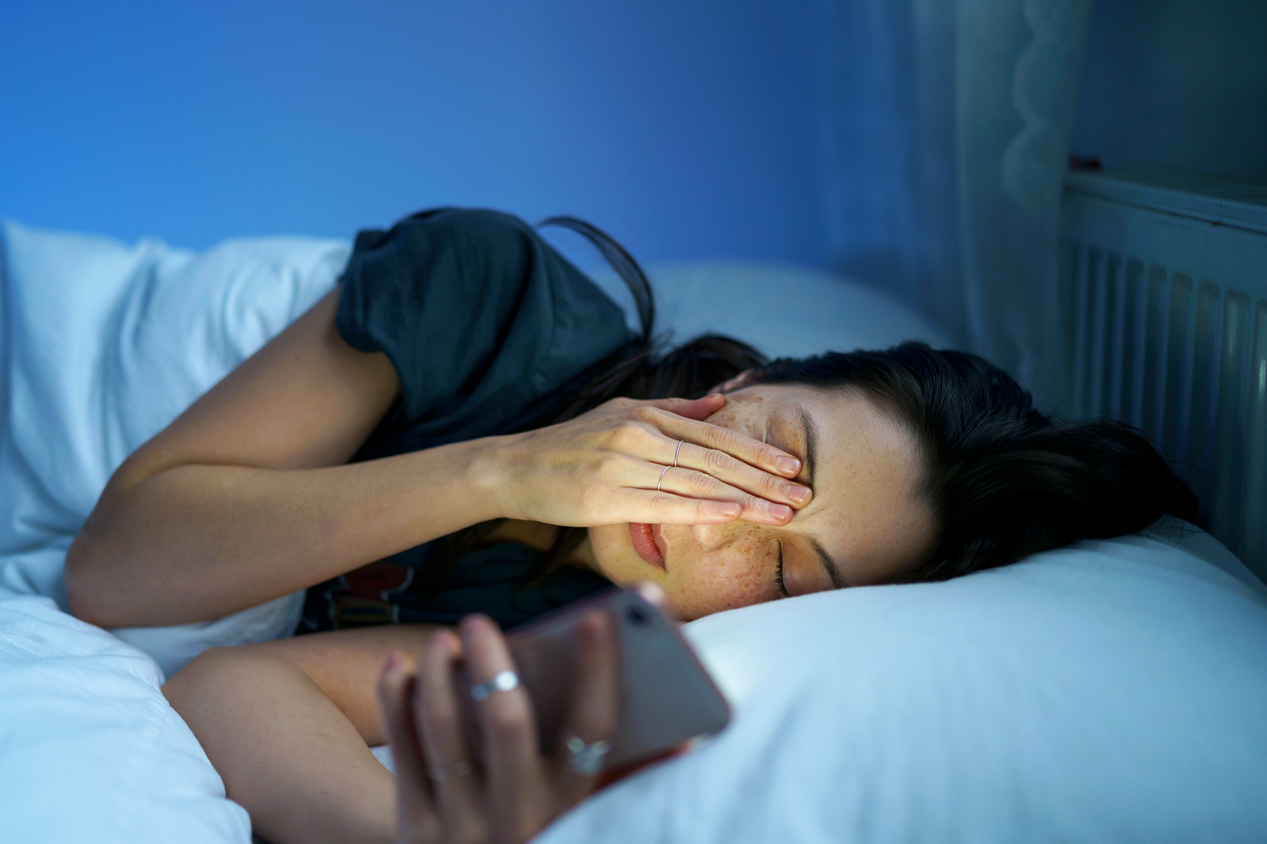 Woman in bed looking at phone