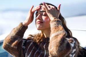 Woman putting sunscreen on in winter