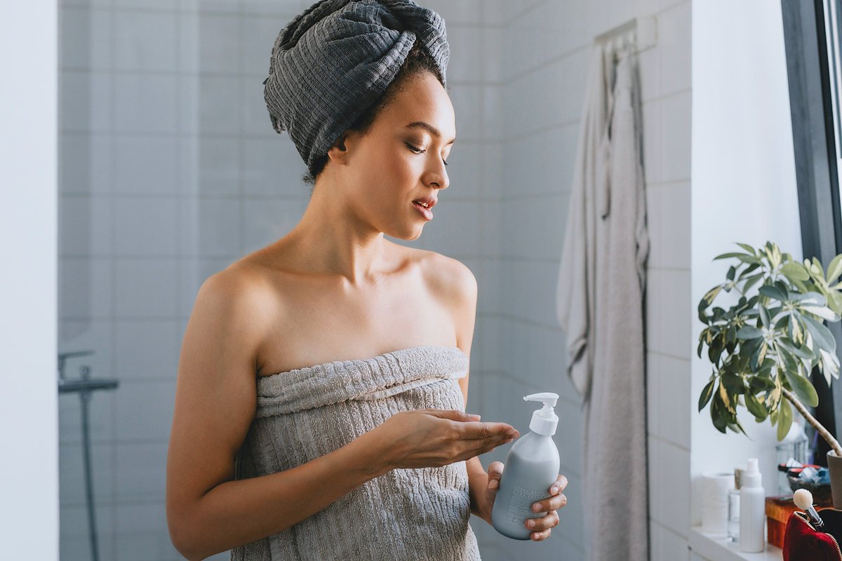 Woman applying lotion after a shower