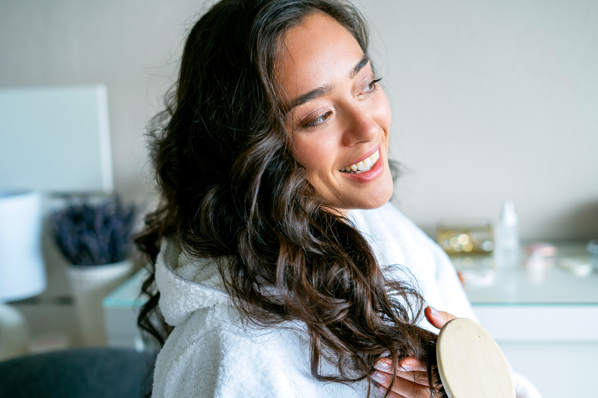 Woman brushing curly hair