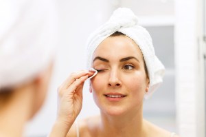 woman removing mascara from eye