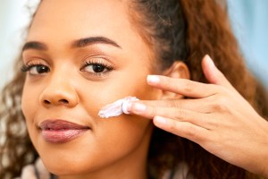 Woman applying sunscreen to her face