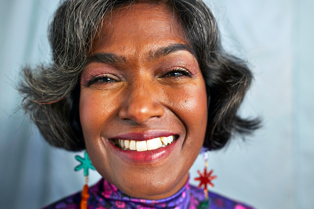 mature woman, smiling, wearing pink, sparkly eye shadow