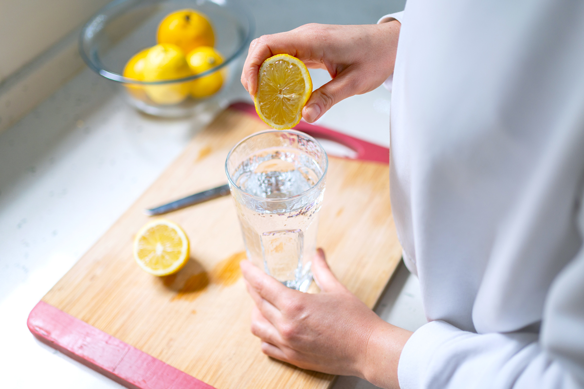 squeezing lemon into glass of water